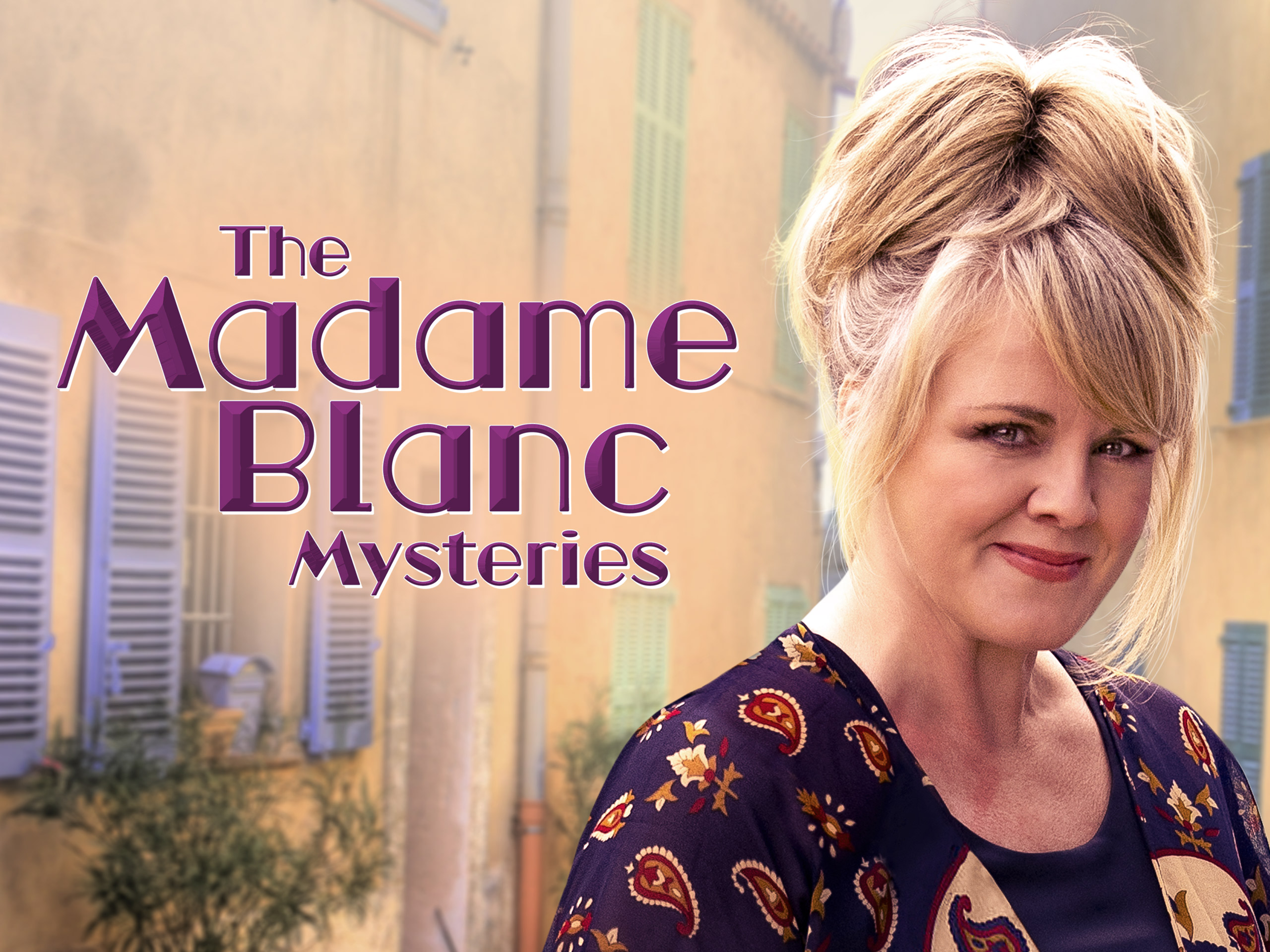 Jean White from The Madame Blanc Mysteries examining an antique in a sunny, picturesque French village square.